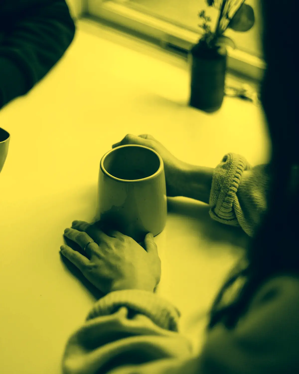 Two people talking over coffee, yellow duotone
